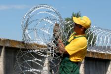 Установка заграждения Гюрза на забор из бетонных плит